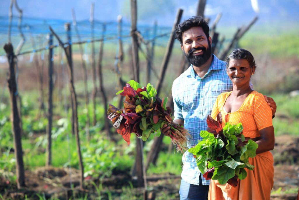 a man and a woman holding flowers in a field